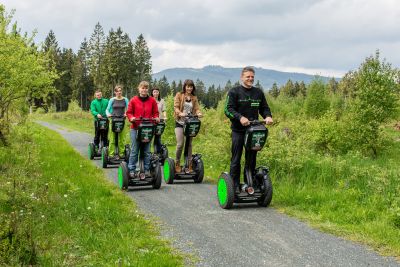 Sechs Personen, die auf Segways einen Wanderweg entlangfahren.