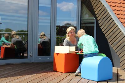 Katrin Burchert spielt mit einem Jungen auf der Dachterrasse.