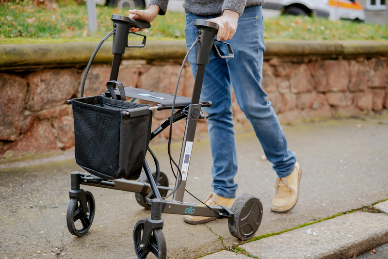 Das Foto zeigt eine Person mit einem Rollator. 