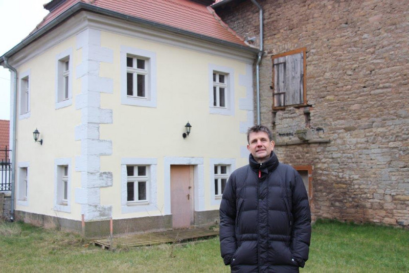 Das Bild zeigt Schlossherr Peter Endres vor dem Torwärterhäuschen des Schlosses Walbeck.