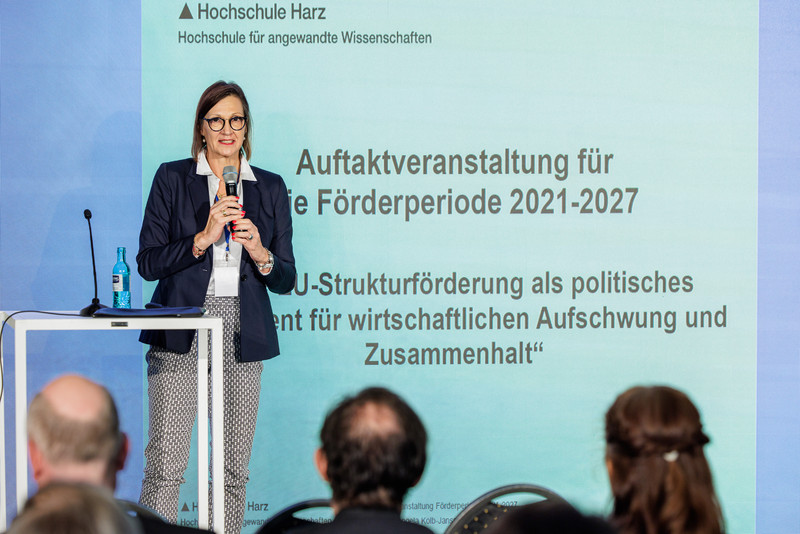 Das Bild zeigt eine Frau beim Vortrag. 