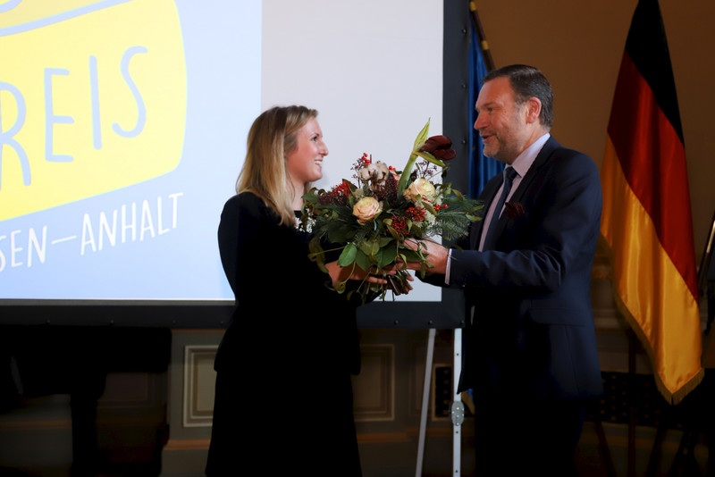 Caroline Lange mit Staatssekretär Dr. Schneider bei der Preisübergabe