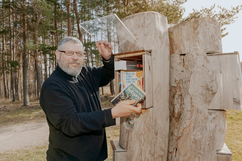 Das Foto zeigt Carsten Passin am Bücherbaum. 