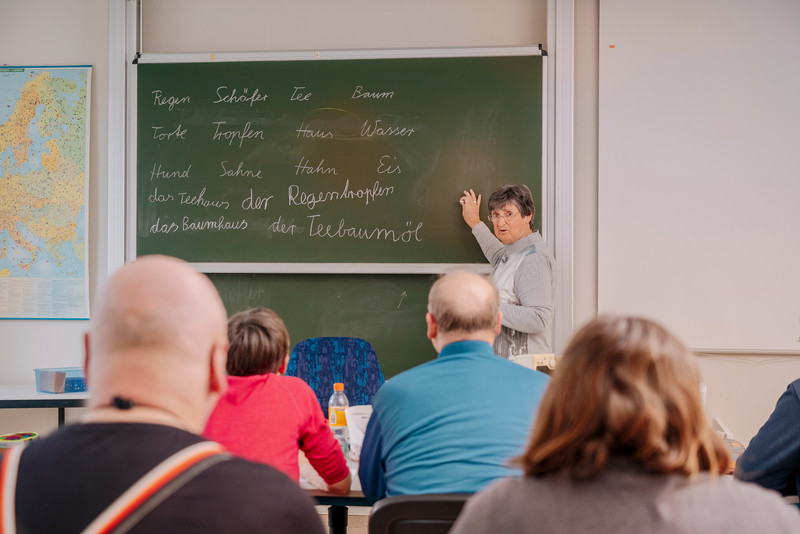 Das Bild zeigt die Teilnehmenden des Kurs mit Blick auf eine Tafel. 