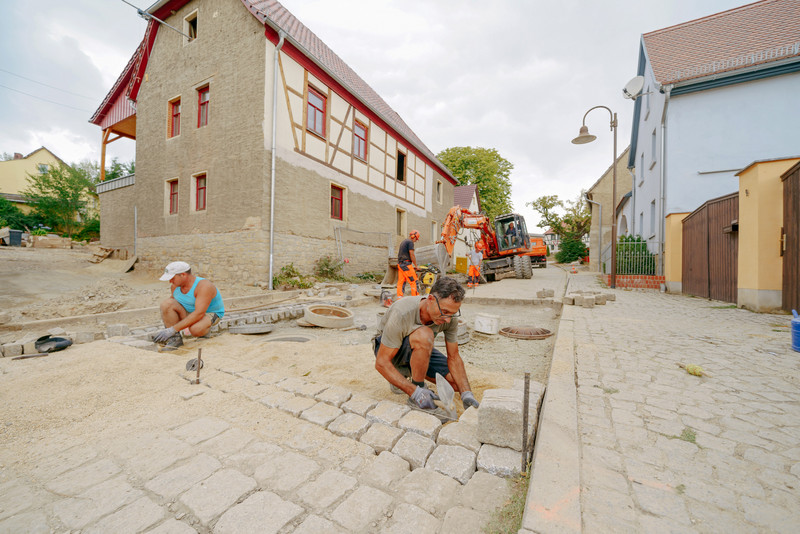 Pflasterarbeiten nach dem die Rohre verlegt wurden